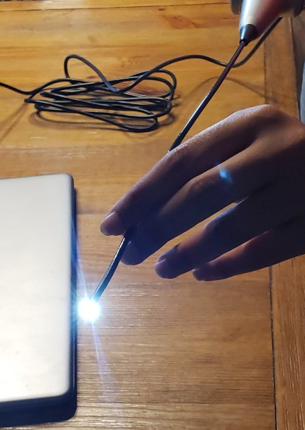 Female hand displaying light from flexible endoscope